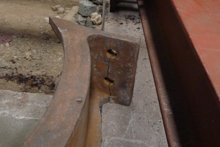Broken flange on the curved end piece of the entablature.