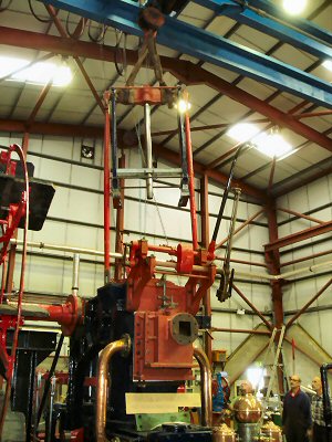 Hoisting the cross-head assembly into position above the steam cylinder.